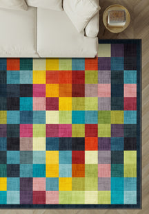 Colorful checkered rug on a wooden floor with a white couch in the background