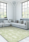 Modern living room with a light gray sectional sofa and a green patterned rug.