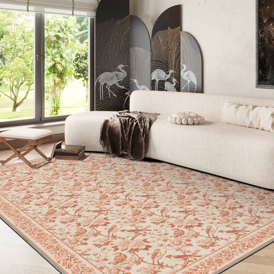 Living room with a patterned rug, white sofa, and large windows.