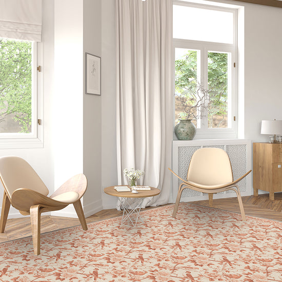Modern living room with patterned rug, chairs, and large windows.