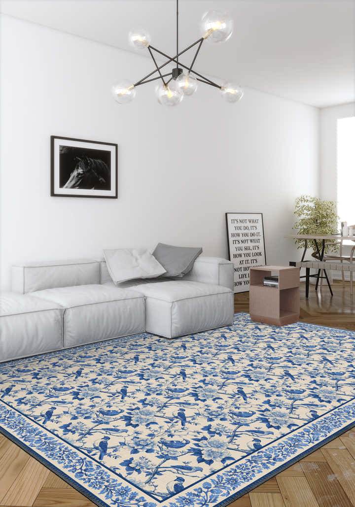 Living room with a blue and white patterned rug, gray sofa, and modern chandelier.