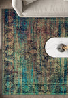 Multicolored patterned rug on a wooden floor with a white chair and table.